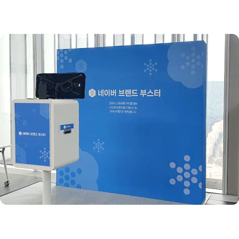 행사장에 설치된 스탠드형 셀프 포토부스 기기와 배경 백월