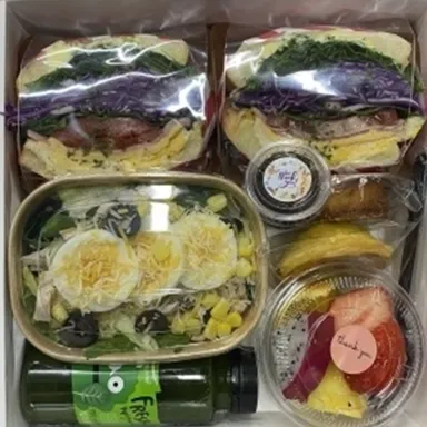 또띠아 랩 샌드위치와 샐러드, 과일컵, 병음료가 담긴 도시락