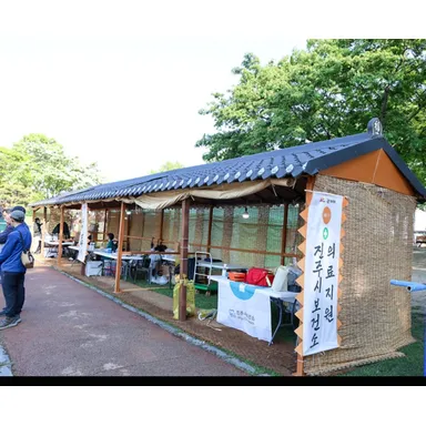 기와 지붕과 나무 기둥으로 만든 전통 축제 부스가 야외에 설치된 모습