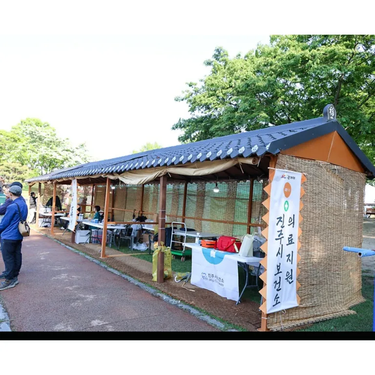 기와 지붕과 나무 기둥으로 만든 전통 축제 부스가 야외에 설치된 모습