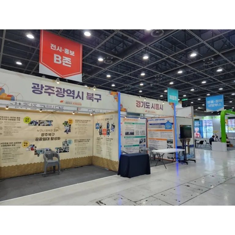 상단 사인 밴드를 얹고 흰 패널로 둘러친 행사장 안내 홍보 부스