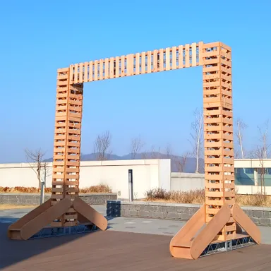 야외에 세운 정사각형 목재 프레임 구조물과 받침 다리