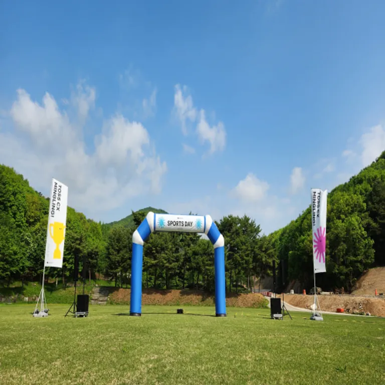 잔디밭에 설치된 파란색 에어아치와 양옆 배너 스탠드