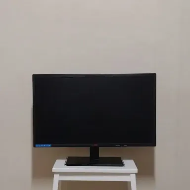 받침대 위에 놓인 24인치 검정 평면 PC 모니터 정면 사진