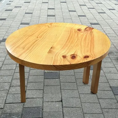밝은 색 원목 상판에 네 다리가 달린 지름 120cm 원형 테이블