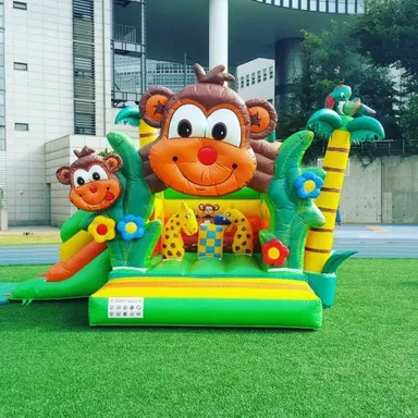 큰 원숭이 얼굴과 야자수 장식이 달린 초록색 공기주입식 놀이 바운스