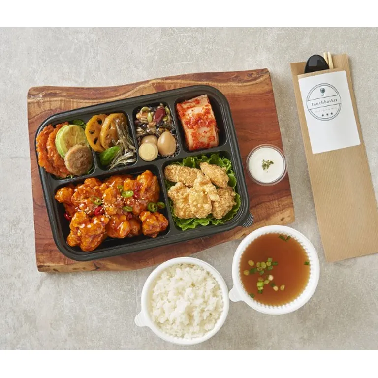 양념 깐풍기와 튀김, 반찬이 담긴 검은 칸막이 도시락과 밥·국