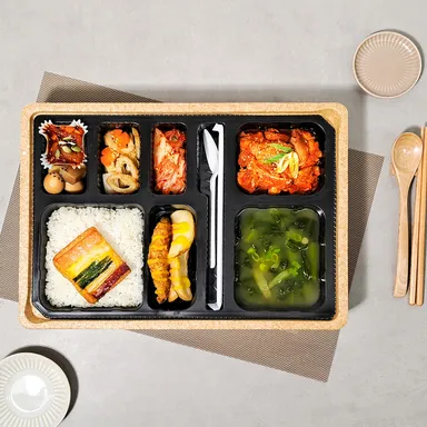 매콤한 닭갈비와 밥, 여러 반찬과 국을 담은 단체 도시락