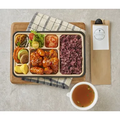깐풍기와 여러 반찬, 흑미밥이 담긴 대용량 도시락과 국물 한 그릇