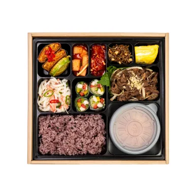 양념 소불고기와 흑미밥, 여러 밑반찬이 칸칸이 담긴 한식 도시락