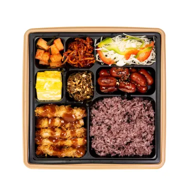 소스를 올린 돈까스와 흑미밥, 여러 밑반찬이 칸칸이 담긴 도시락