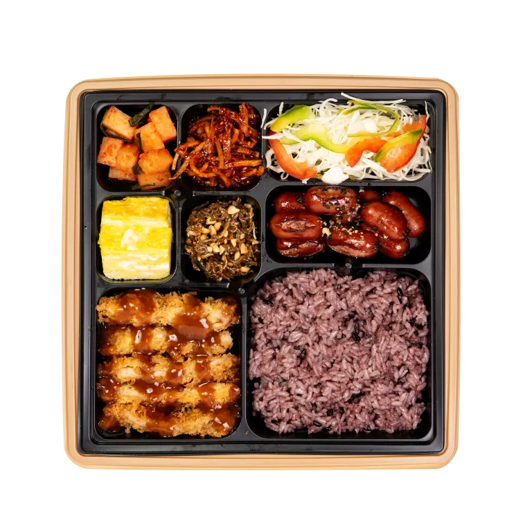 소스를 올린 돈까스와 흑미밥, 여러 밑반찬이 칸칸이 담긴 도시락